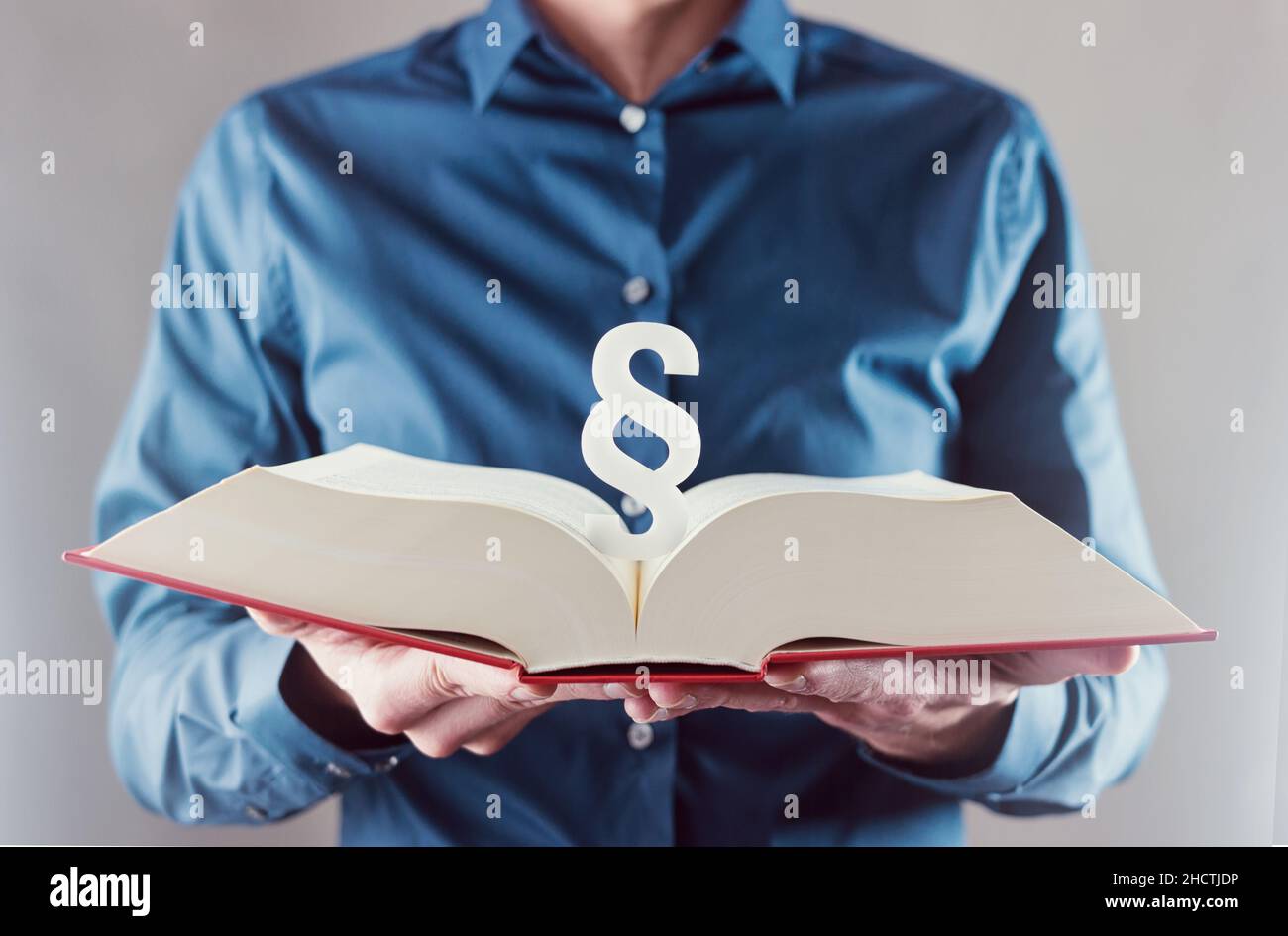 Junger Mann hält Buch mit Absatz Zeichen - Gesetz Konzept Bild Stockfoto