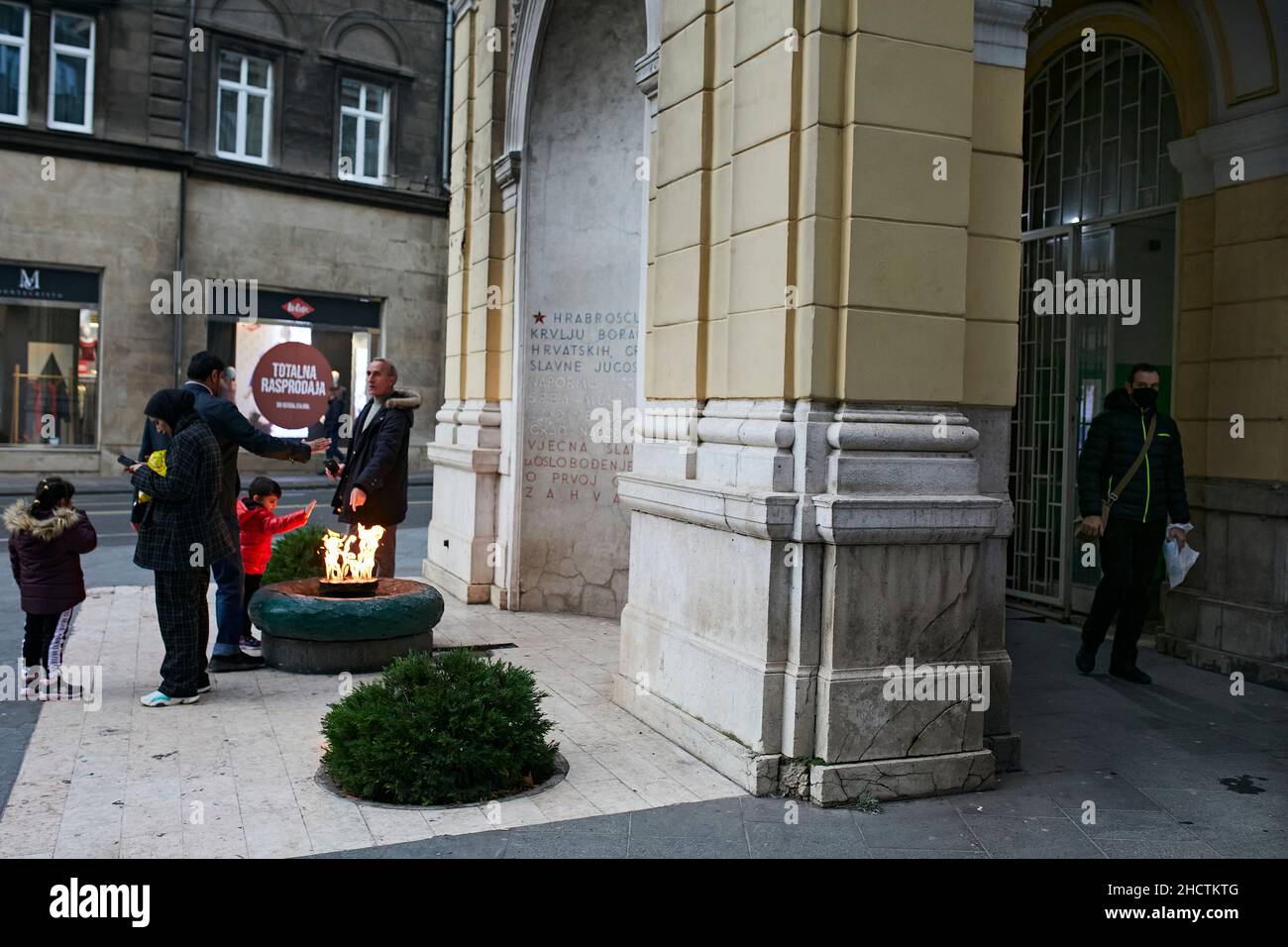 Touristen vor der "Ewigen Flamme", einem Denkmal für die militärischen und zivilen Opfer des Zweiten Weltkriegs im Zentrum von Sarajevo. Stockfoto