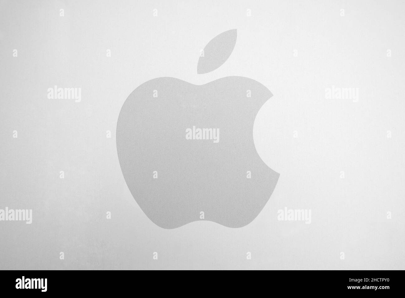 Weißes Apple-Logo auf gebürstetem Aluminium-Hintergrund. Apple ist das weltweit größte börsennotierte Unternehmen, das Unterhaltungselektronik und Kombis entwickelt und verkauft Stockfoto