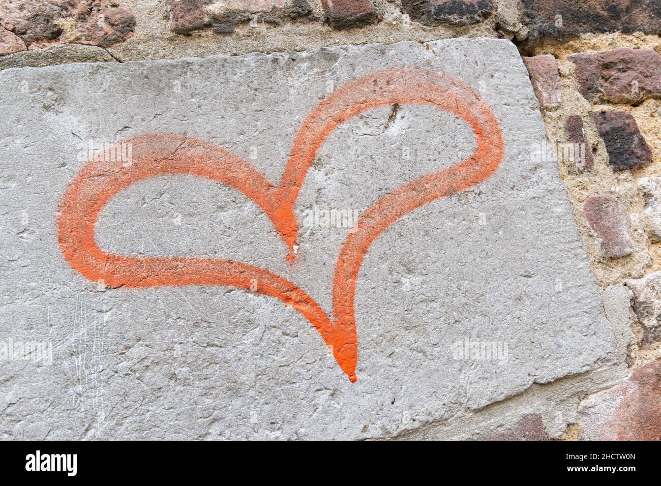 Konzept oder konzeptuell gemalte rote abstrakte Herzform Liebe Symbol, schmutzige Wand Hintergrund, Metapher für urbane und romantische valentin Stockfoto