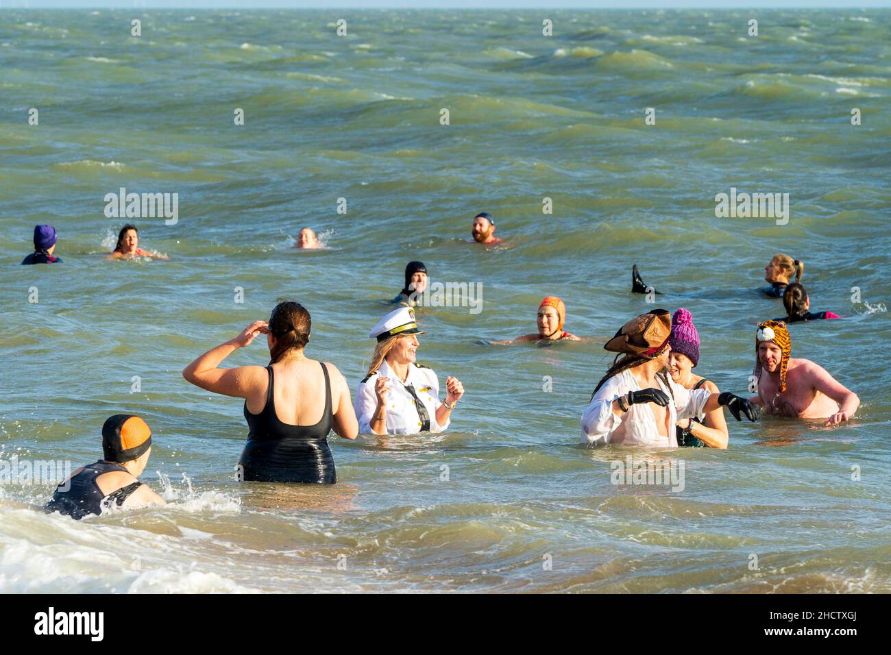 Menschen jeden Alters, die im Meer stehen, nachdem sie zum traditionellen Neujahrstauchen in den englischen Ferienort Ramsgate hinübergeeilt sind. Stockfoto