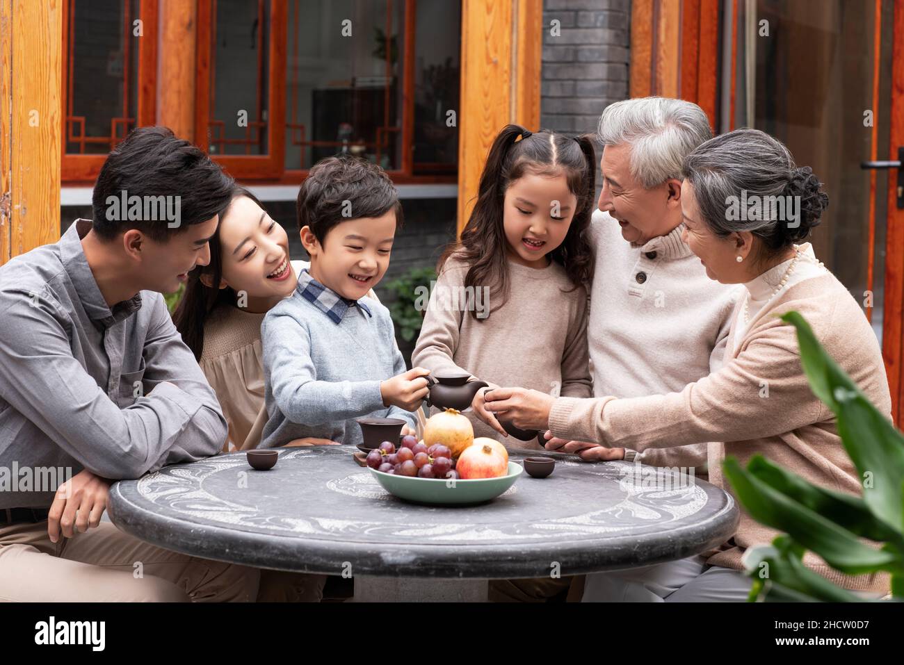 Glückliche Familien, die Tee trinken und im Innenhof plaudern Stockfoto