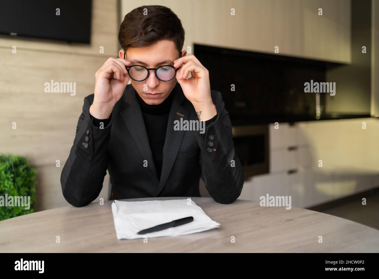 Konzept für Gesundheitsprobleme. Verminderte Sicht eines Mannes mit Brille, Kopfschmerzen eines Büroangestellten, Schmerzen des Geschäftsmannes in den Augen, Arbeit zu Hause Stockfoto