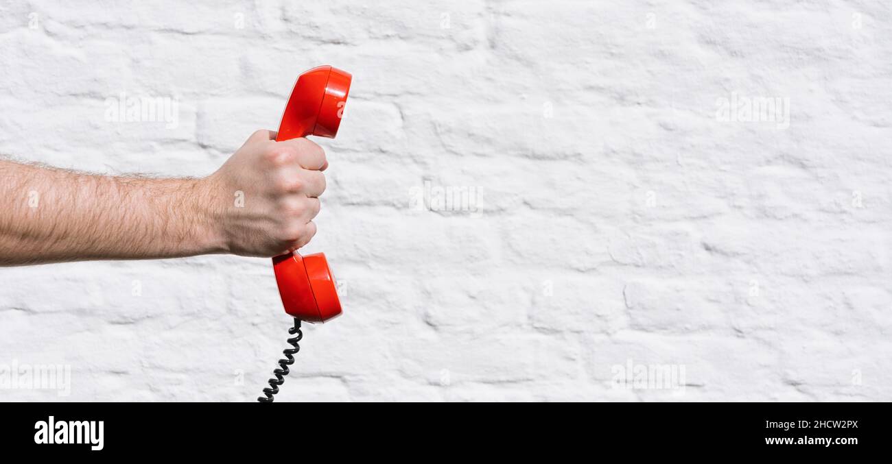 Roter Telefonanruf für Sie gegen eine weiße Ziegelmauer Stockfoto