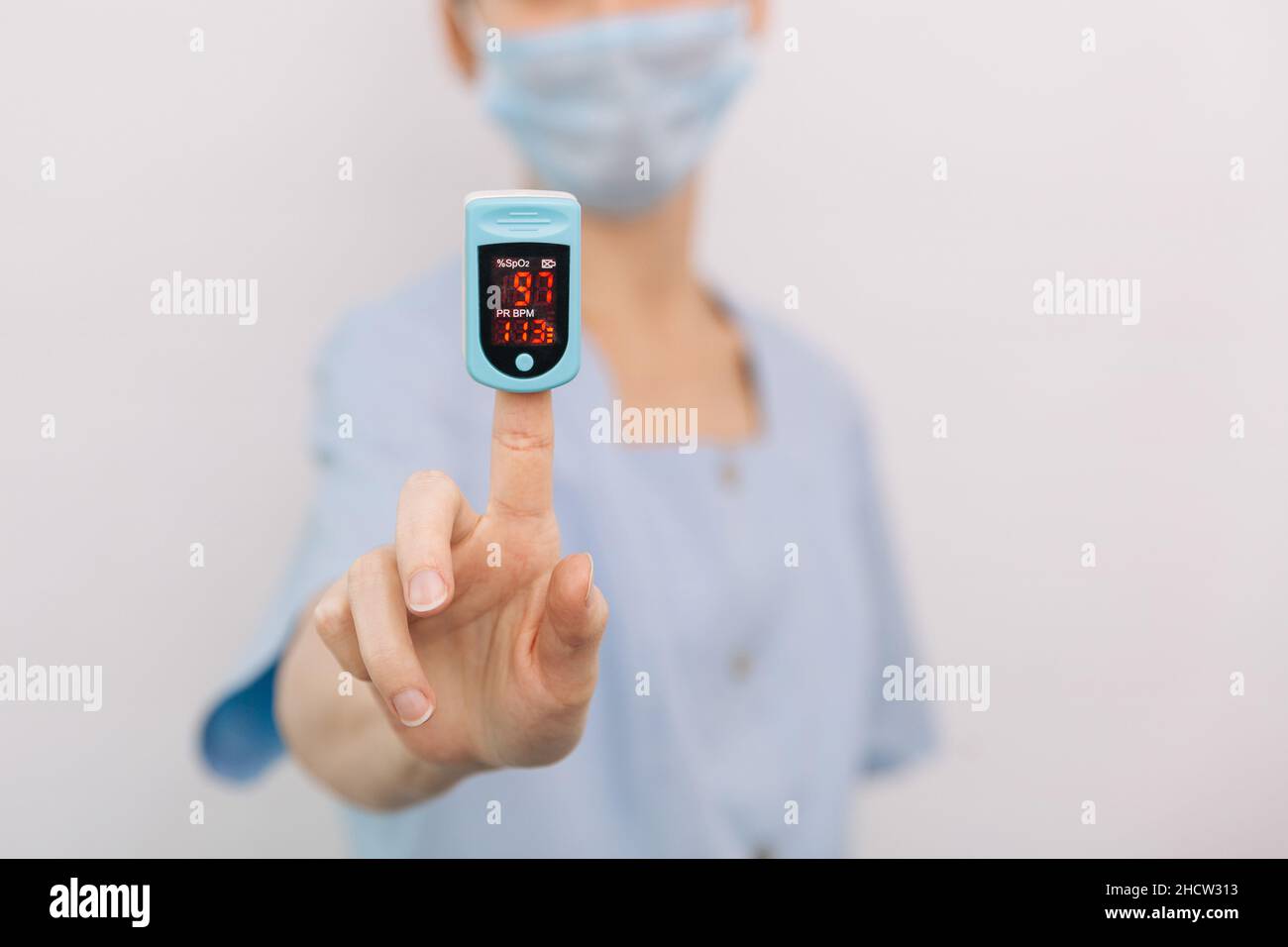 Pulsoximeter mit der Hand des Arztes auf Weiß isoliert. Das Konzept eines tragbaren digitalen Geräts zur Messung der Sauerstoffsättigung von Personen. Messung von Sauerstoff Stockfoto