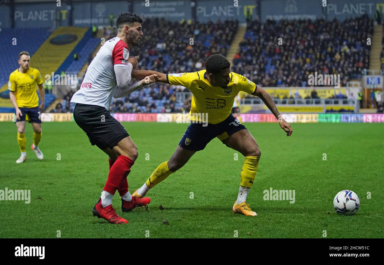 Conor Thomas von Cheltenham Town und Marcus McGuane von Oxford United (rechts) kämpfen während des Sky Bet League One-Spiels im Kassam Stadium, Oxford, um den Ball. Bilddatum: Samstag, 1. Januar 2022. Stockfoto