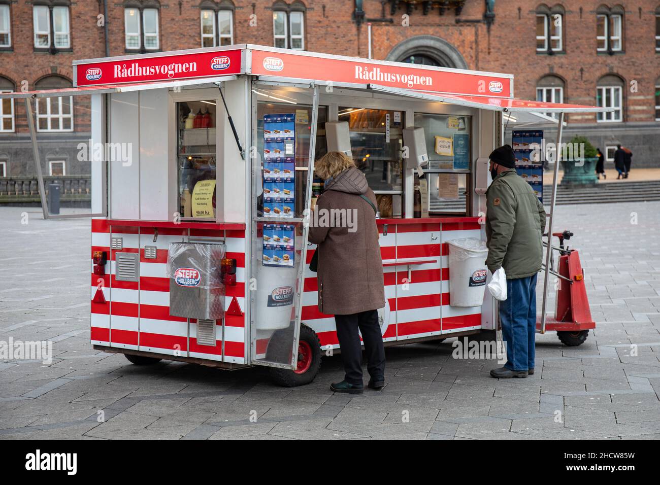 Leute, die Fastfood von Rådhusvognen Hot Dog Stand oder van auf Rådhuspladsen in Kopenhagen, Dänemark, kaufen Stockfoto
