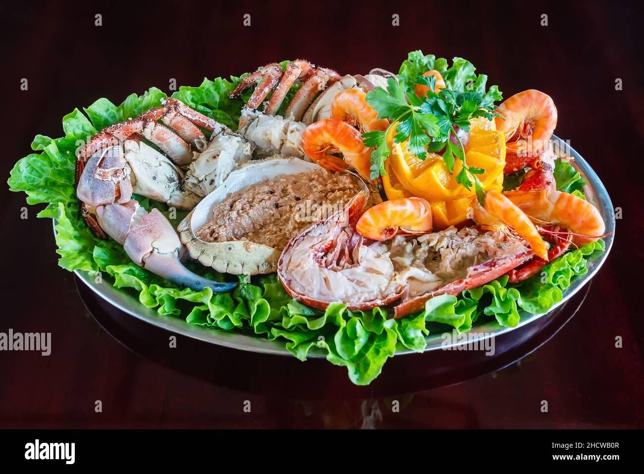 Variationen von Meeresfrüchten in einer Metallplatte für einen Aperitif in einem Restaurant mit Gemüse. Delikatessen aus der Nähe vom Meer auf dem Tisch. Stockfoto