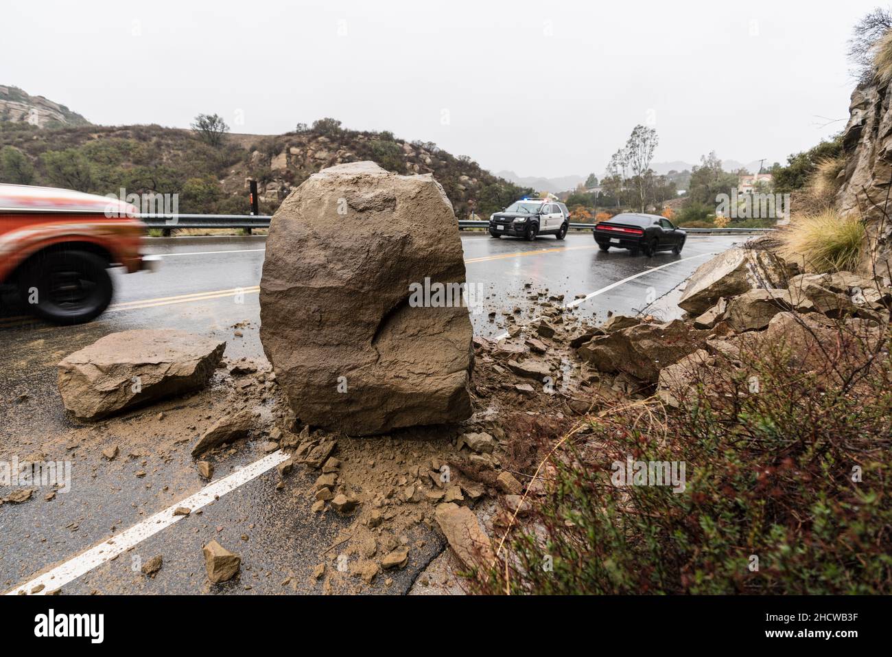Los Angeles, Kalifornien, USA - 30. Dezember 2021: Los Angeles Polizeiauto, das den Verkehr beobachtet, verfährt eine blockierte Spur vom Erdrutsch auf dem Santa Susana Pass Stockfoto
