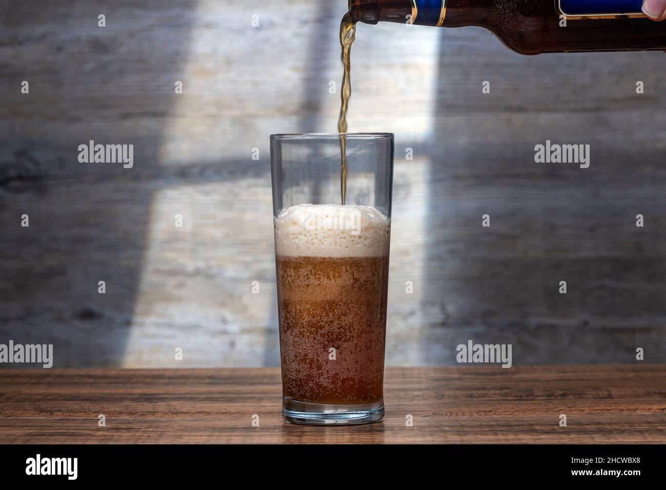 Ein Glas Ale aus einer Flasche gießen. Stockfoto