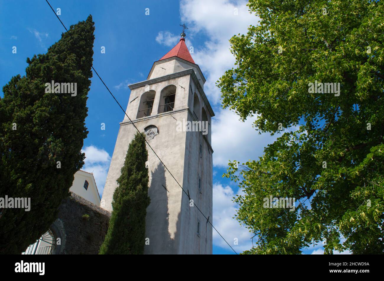 Kirche des heiligen Markus mit beeindruckendem Glockenturm, umgeben von Zypressen und Linden, in einer kleinen Stadt auf dem Hügel Veprinac, oberhalb der Riviera Opatija, Stockfoto