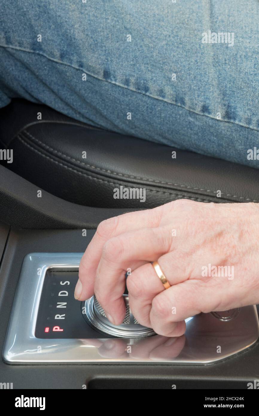 Eine Frau, die den Gangwahlschalter in einem automatischen Fahrzeug verwendet - in diesem Fall ein Land Rover Discovery. Stockfoto