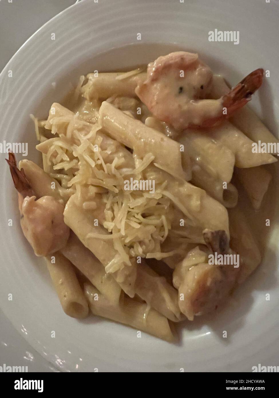 Leckere Pasta Carbonara mit Garnelen und Käse. Typisch italienisches Gericht auf einem weißen Teller aus der Nähe. Stockfoto