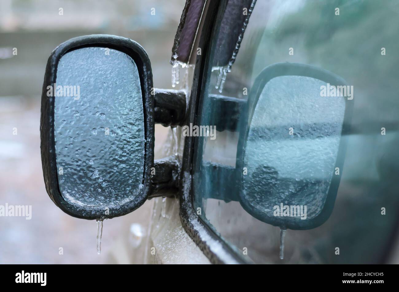 Eisgefrieren auf dem Autospiegel während der atmosphärischen Vereisung. Schlechtes Fahrwetter. Stockfoto