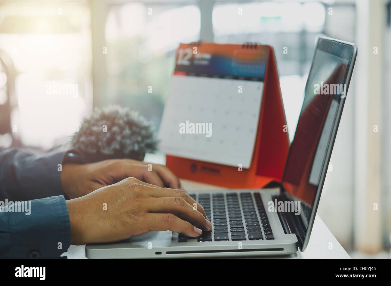 Der Geschäftsmann sucht auf einem Laptop an seinem Schreibtisch nach Internet-Geschäftsinformationen. Stockfoto