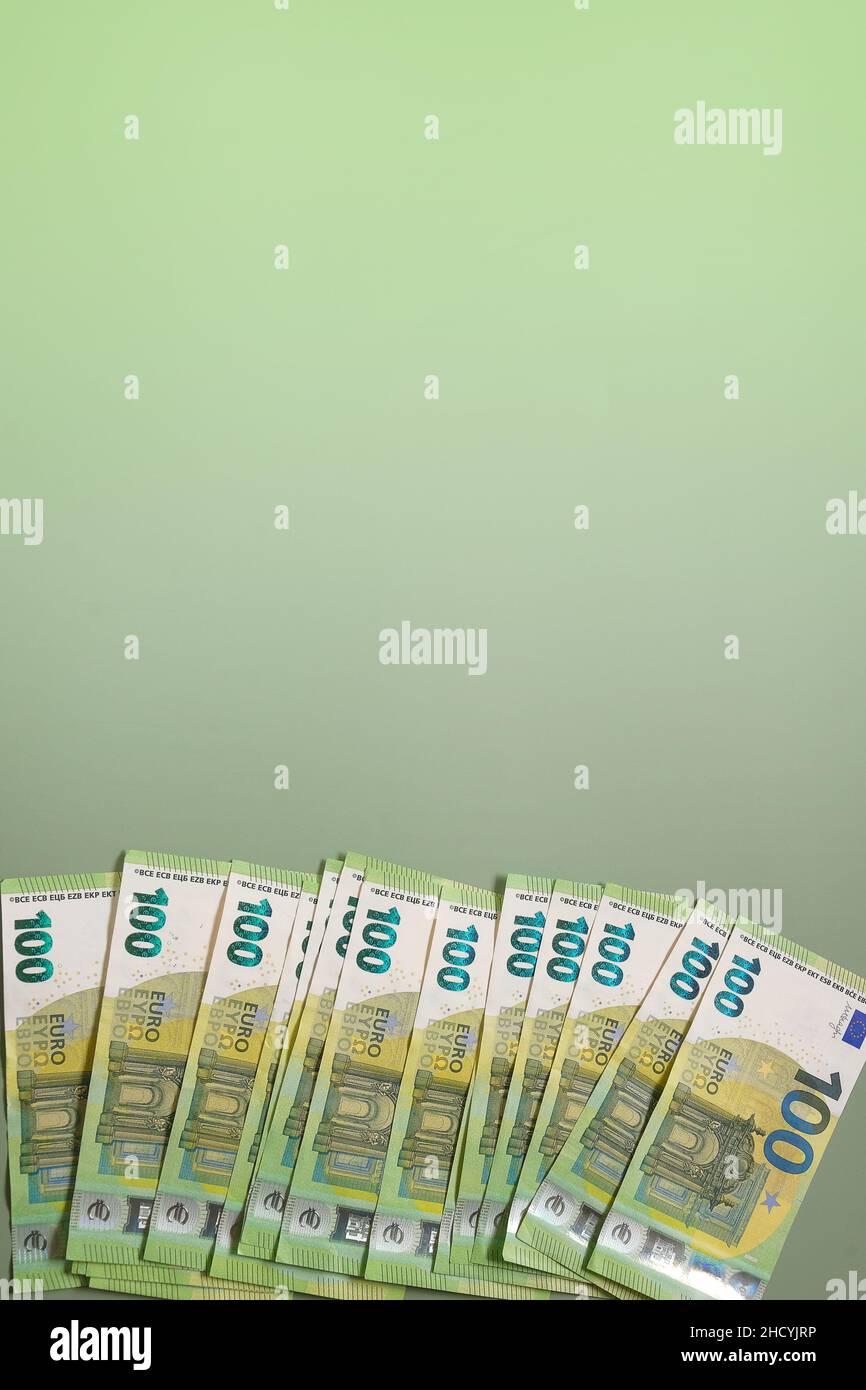 Euro-Währung.Geld und Finanzen. Hundert Euro-Banknoten auf grünem Hintergrund.Euro-Banknoten bündeln sich auf grünem Hintergrund. Stockfoto