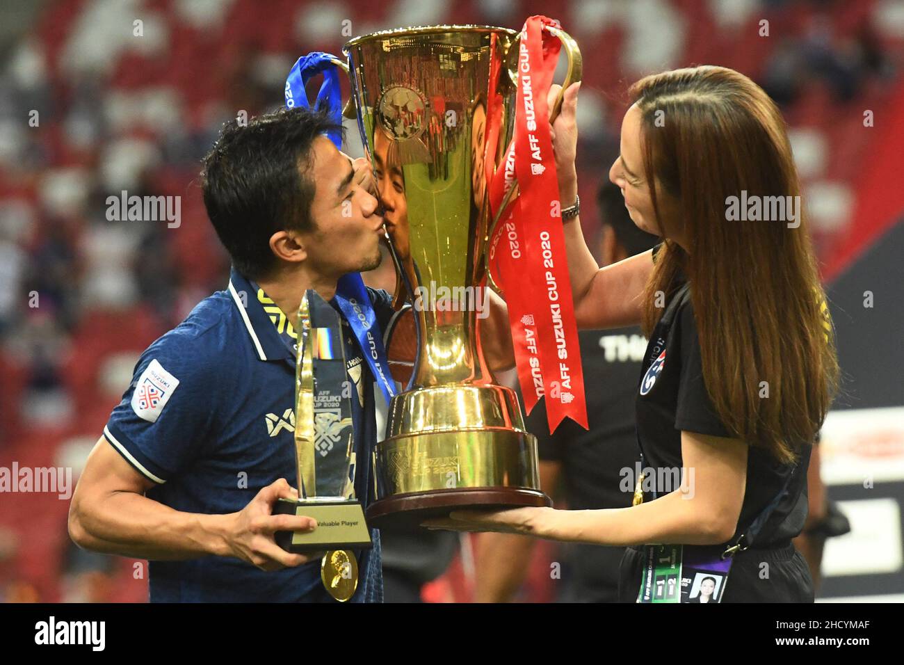 Singapur. 1st Januar 2022. Chanathip Songkrasin (L) aus Thailand und Teamchef Nualphan Lamsam halten die Trophäe während der Siegerehrung, nachdem Thailand am 1. Januar 2022 in Singapur das zweite Finale des ASEAN Football Federation (AFF) Suzuki Cup 2020 mit Indonesien gewonnen hat. Quelle: Then Chih Wey/Xinhua/Alamy Live News Stockfoto