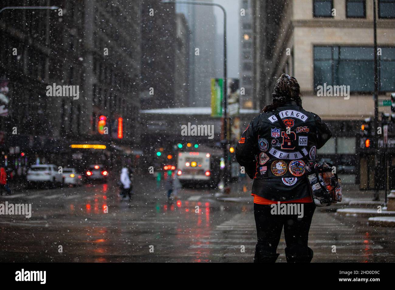 Chicago, USA. 1st Januar 2022. Eine Frau wartet darauf, die Michigan Ave in der Innenstadt von Chicago, USA, zu überqueren, 1. Januar 2022. Ein Wintersturm traf Chicago am Samstag, mit Schneeansammlungen, die voraussichtlich 10 bis 18 Zentimeter erreichen werden. Kredit: Vincent D. Johnson/Xinhua/Alamy Live Nachrichten Stockfoto