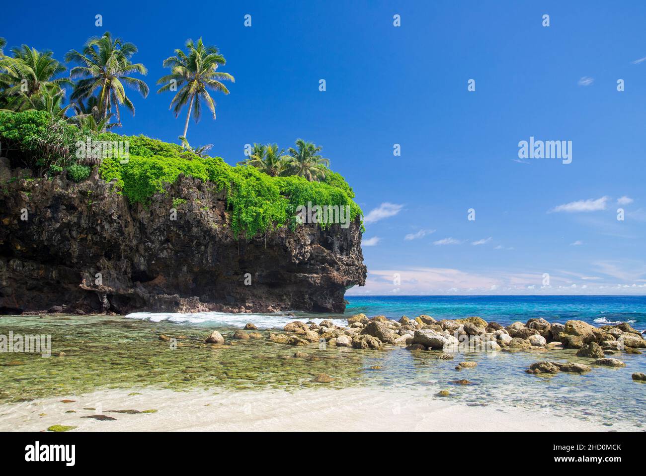 Ein kleiner Strand und Palmen auf den Klippen in der Nähe des stillgelegten Christmas Island Resort und Casino. Stockfoto