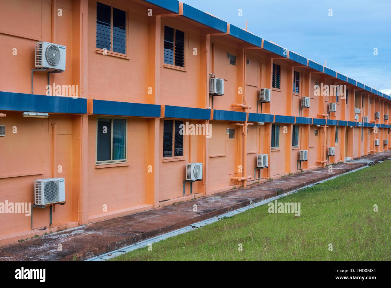Klimaanlagen, die an der Außenseite eines orangefarbenen Apartmentblocks in Poon Saan montiert sind, einer Siedlung über Flying Fish Cove auf Christmas Island. Stockfoto