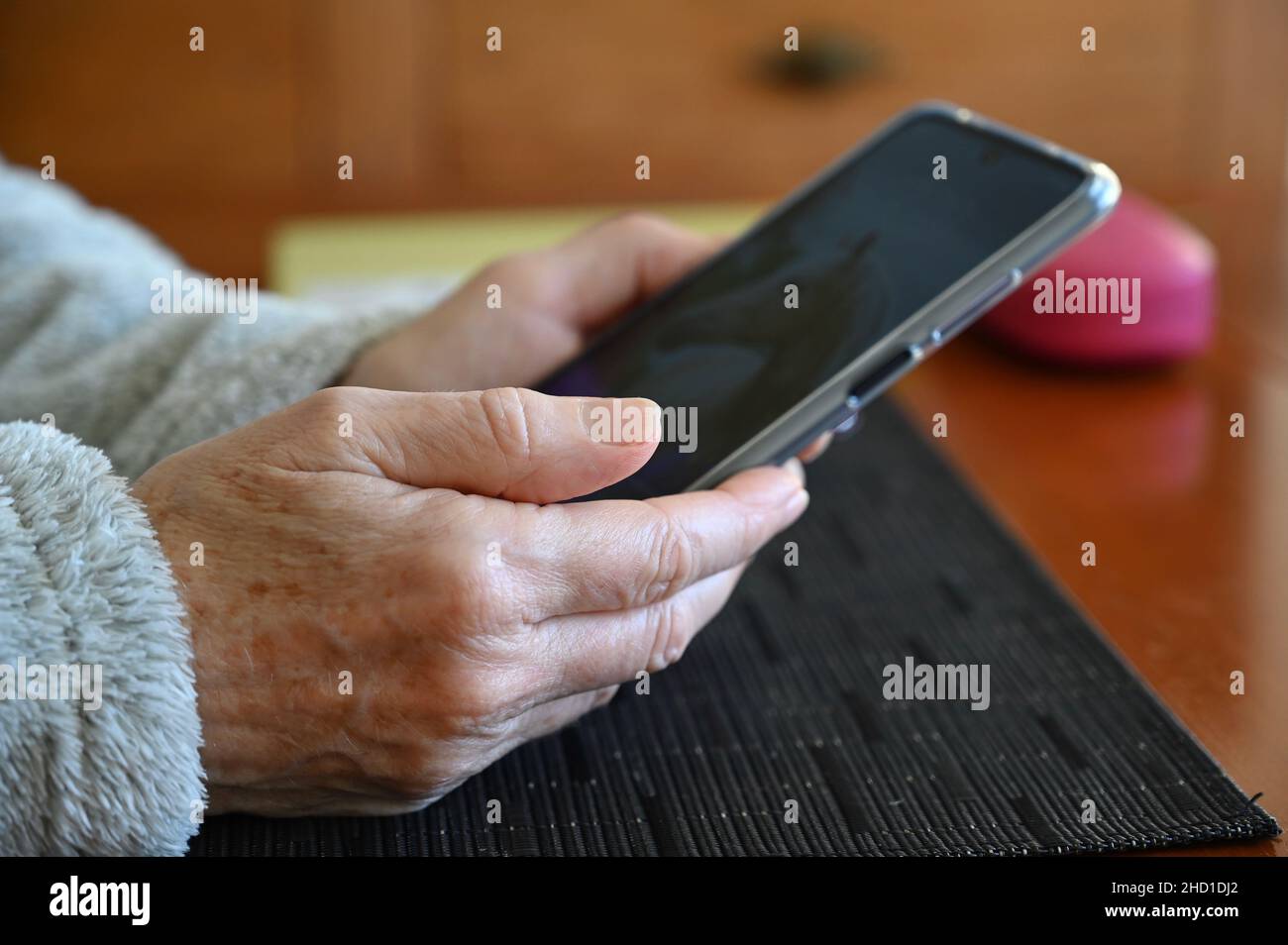 Nahaufnahme einer älteren Frau mit einem Mobiltelefon. Stockfoto