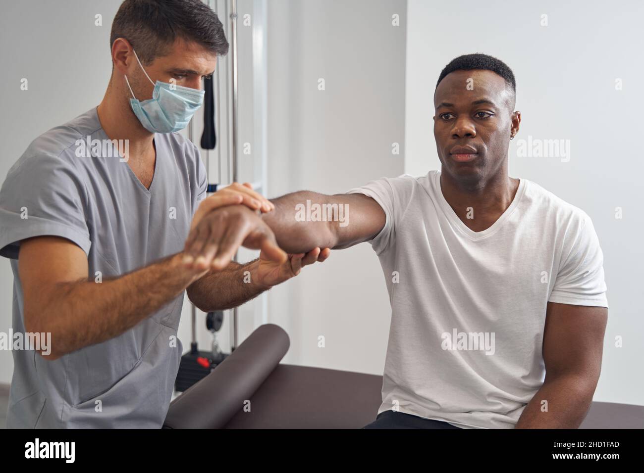 Junger Mann, der seine Muskelkraft beurteilen ließ Stockfoto