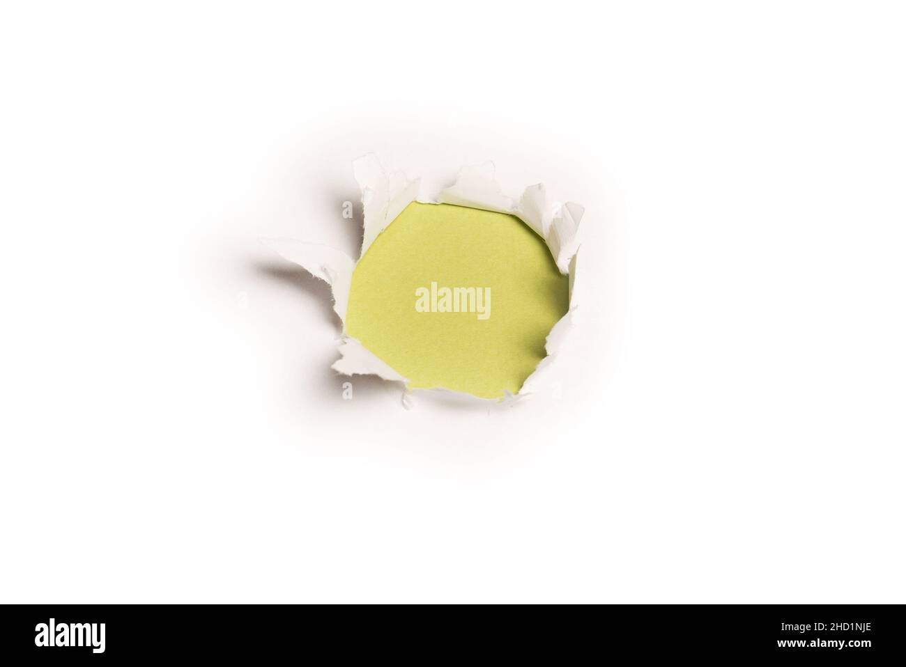 Ein Loch in einem weißen Papier auf einem grünen Hintergrund, Platz kopieren. Stockfoto