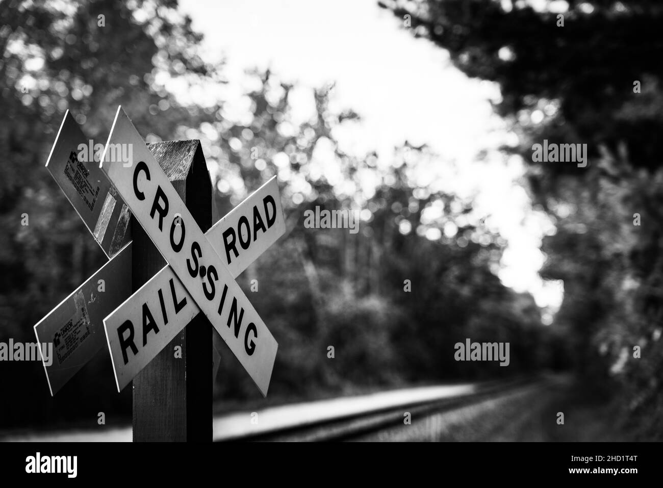 Graustufenaufnahme eines Schildes mit dem Text 'Crossing, Railroad' Stockfoto