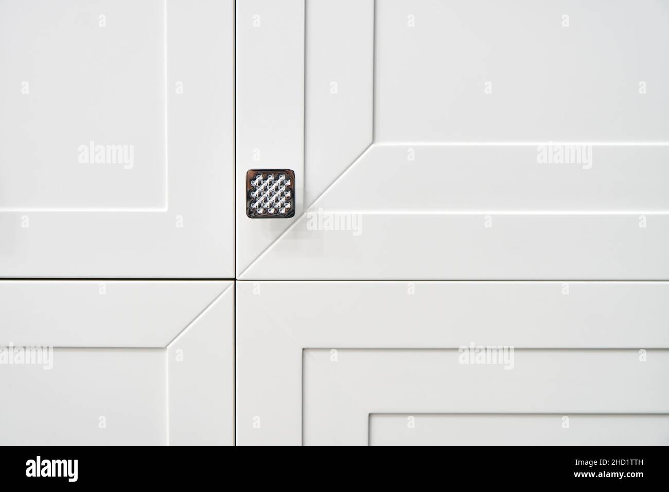 Moderne, weiße Schranktüren mit Metallgriff in hellen Toiletten, extreme Nahsicht Stockfoto