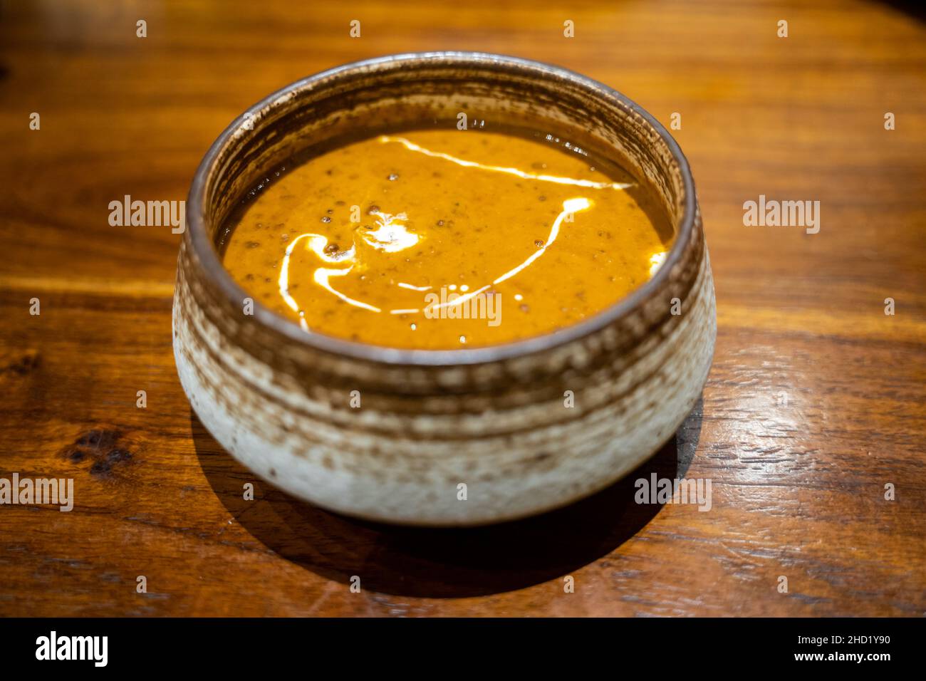 Eine Schüssel mit köstlichem Dal makhani, indischem Linsencryl mit Creme auf einem Holztisch Stockfoto