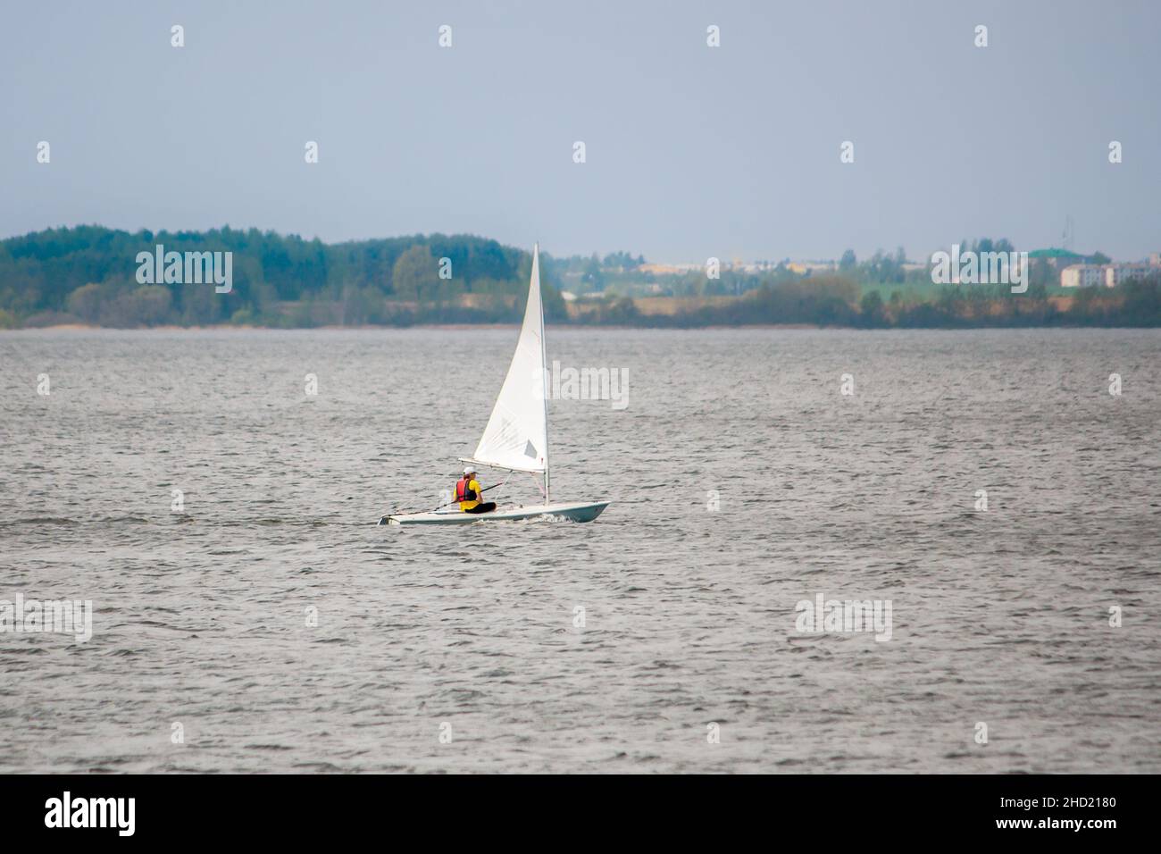 Yachting. Kleine Yacht mit einem Besatzungsmitglied, das durch die Wellen rast. Die Ausbildung der jungen Segler auf dem Saslawski Stausee bei Minsk. Stockfoto