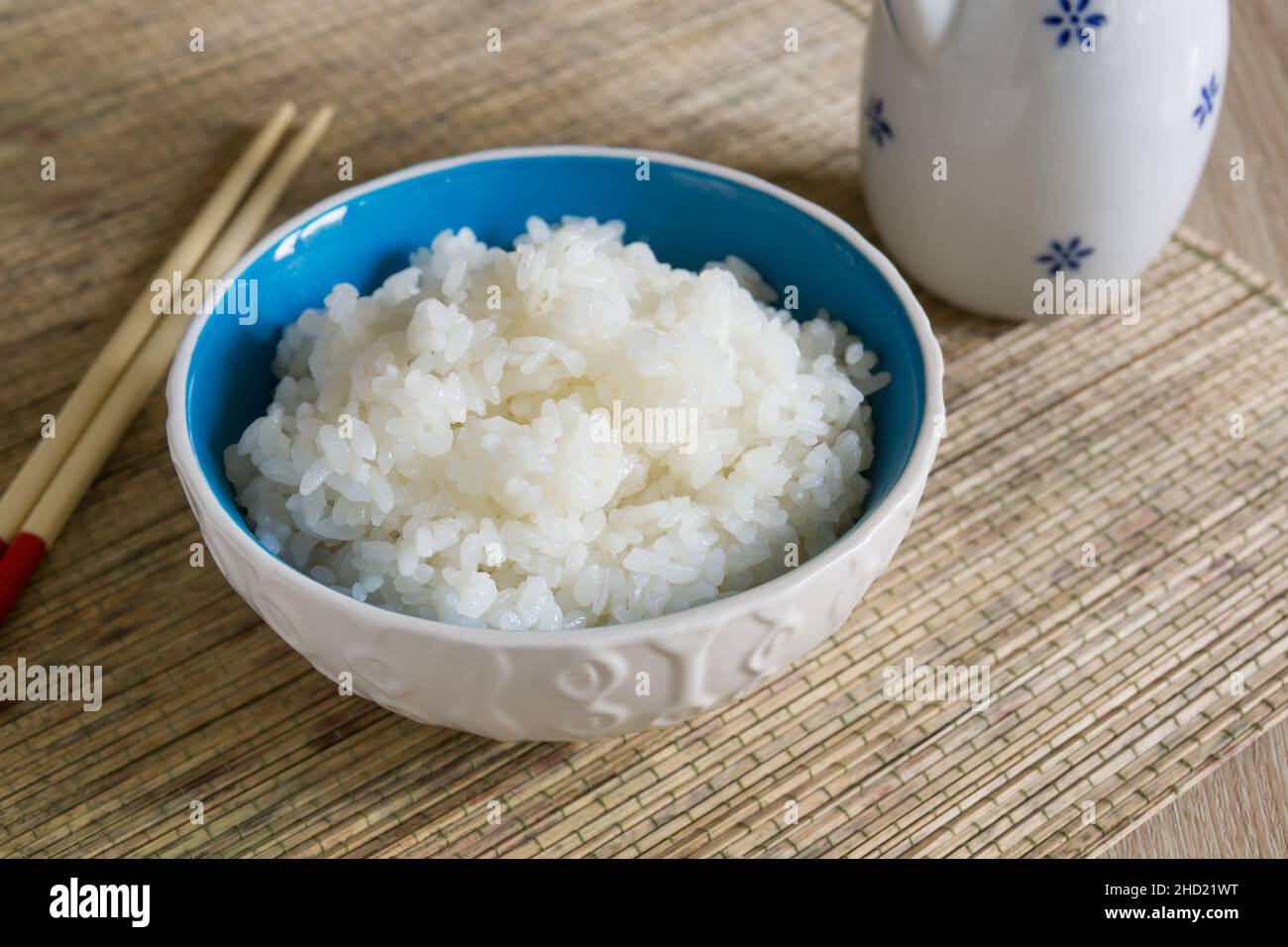 Japanischer Uruchimai-Reis in einem hübschen Keramikschüssel mit Essstäbchen gedämpft Stockfoto