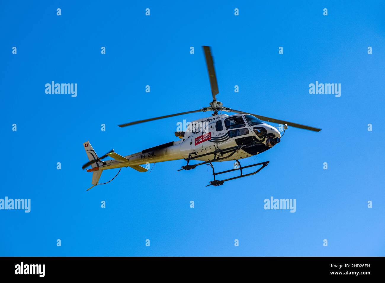 Ein Hubschrauber mit Rennfunktionären, die bei der Tour de Suisse 2021 über die Tremola San Gottardo fliegen. Stockfoto