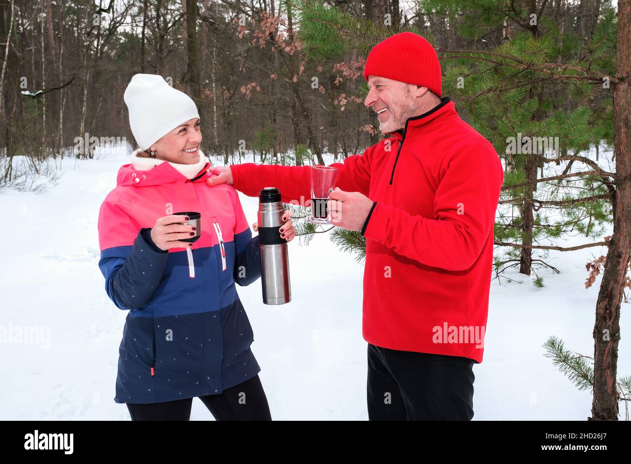 Paar trinken warme Getränke im Winter Park Stockfoto