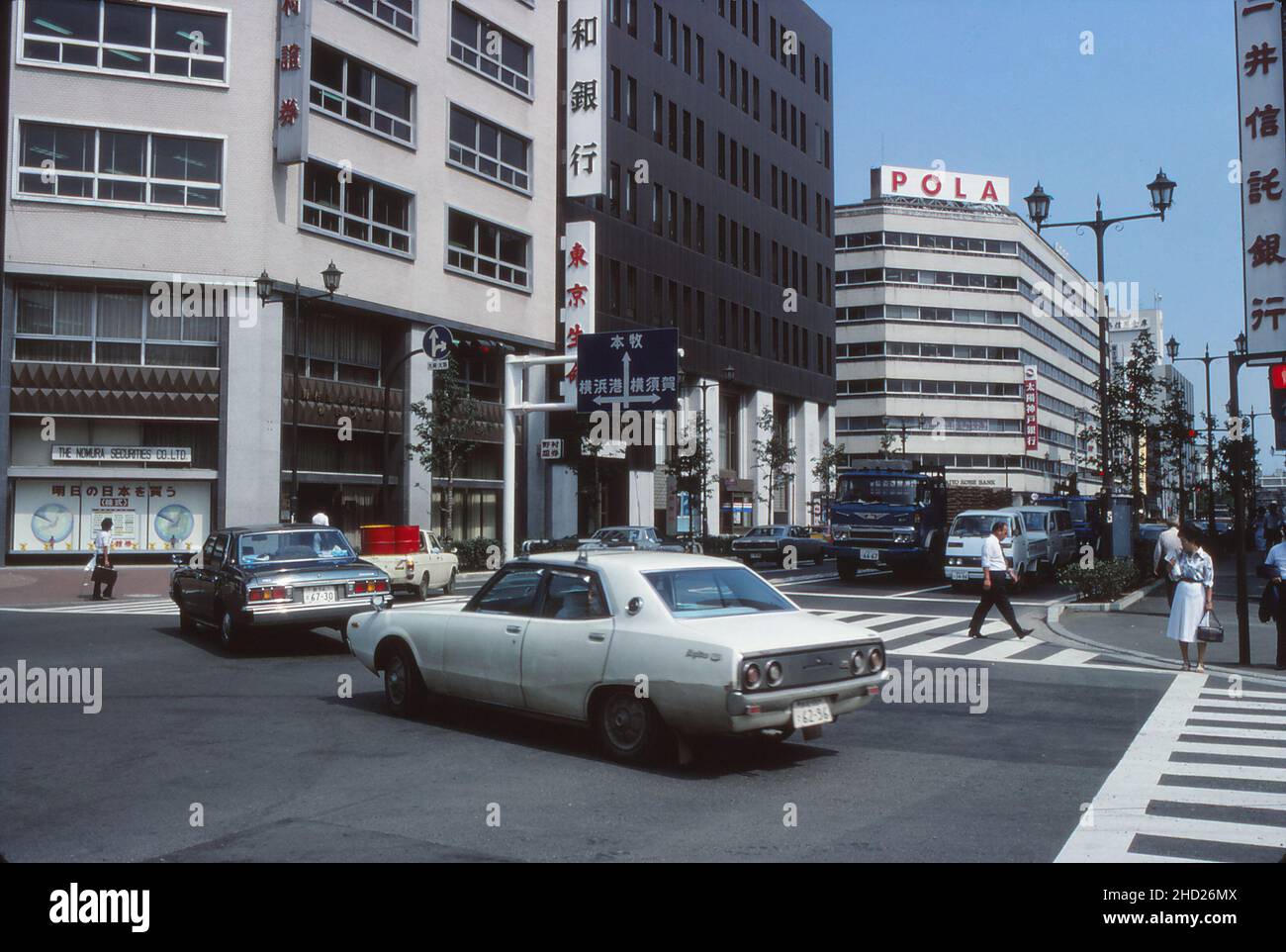 Kreuzung, Kreuzung, Yokohama, Japan, mit Schild nach Honmoku, Yokohama Port und Yokosuka. Dazu gehören auch Nomura Securities, die Taiyo Kobe Bank und das Pola-Gebäude. August 1977 Stockfoto