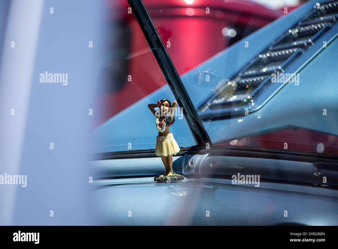 Kleine Figur eines Mädchens in einem Auto vor dem Fenster Stockfoto