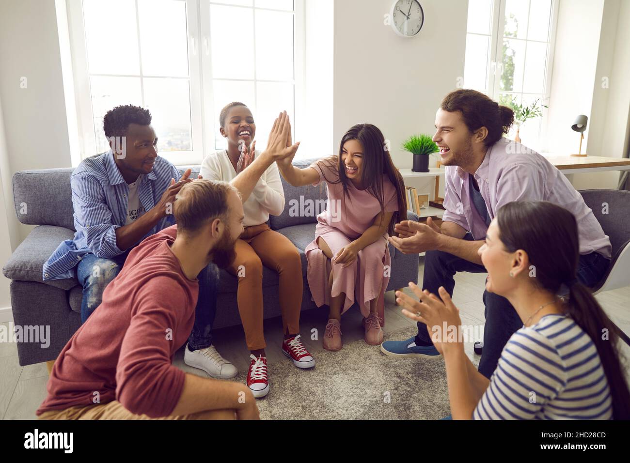 Lächelnde, vielfältige Menschen geben High Five zusammen Stockfoto