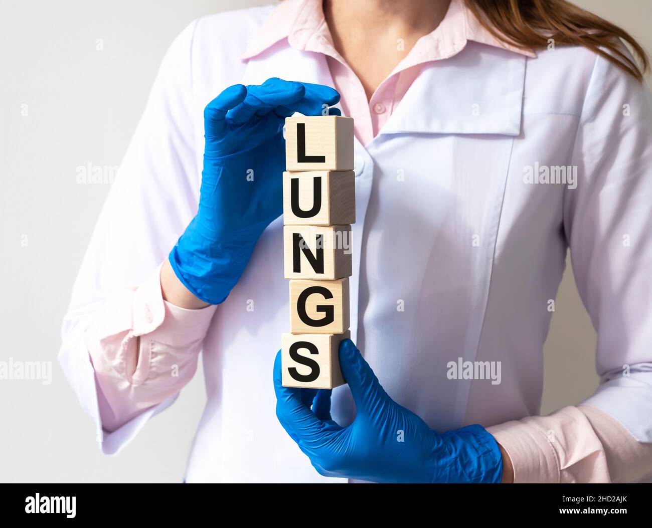 LUNGEN Wort auf Würfel Blöcke in den Händen in den medizinischen Handschuhen einer Ärztin Stockfoto