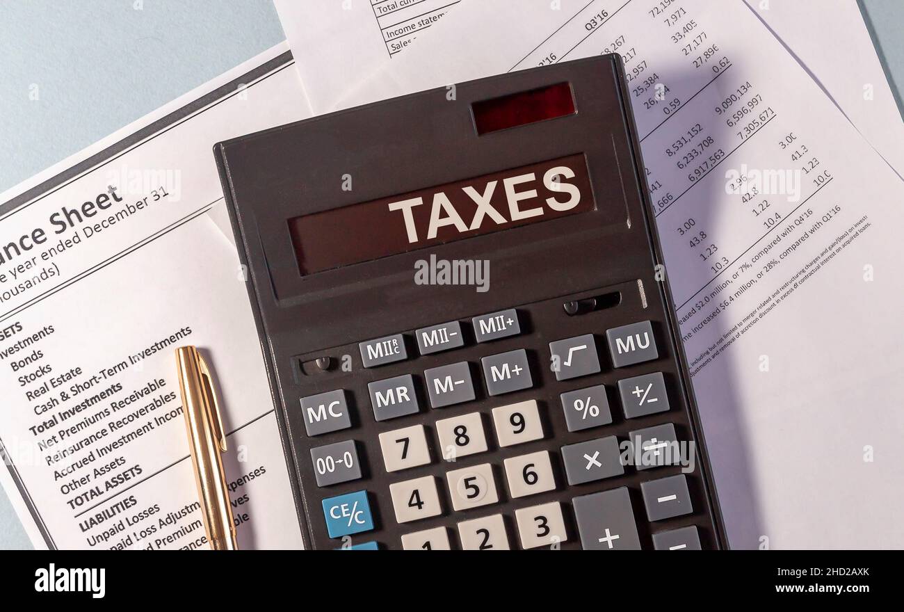 TAXS Wort auf dem Display des Rechners auf Papier Dokumente und goldenen Stift Stockfoto