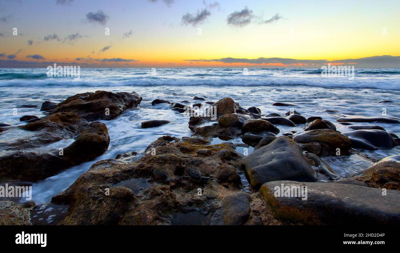 Panoramablick auf das Meer und den steinigen Strand bei Sonnenuntergang, Teneriffa, Spanien. Seascape Stockfoto