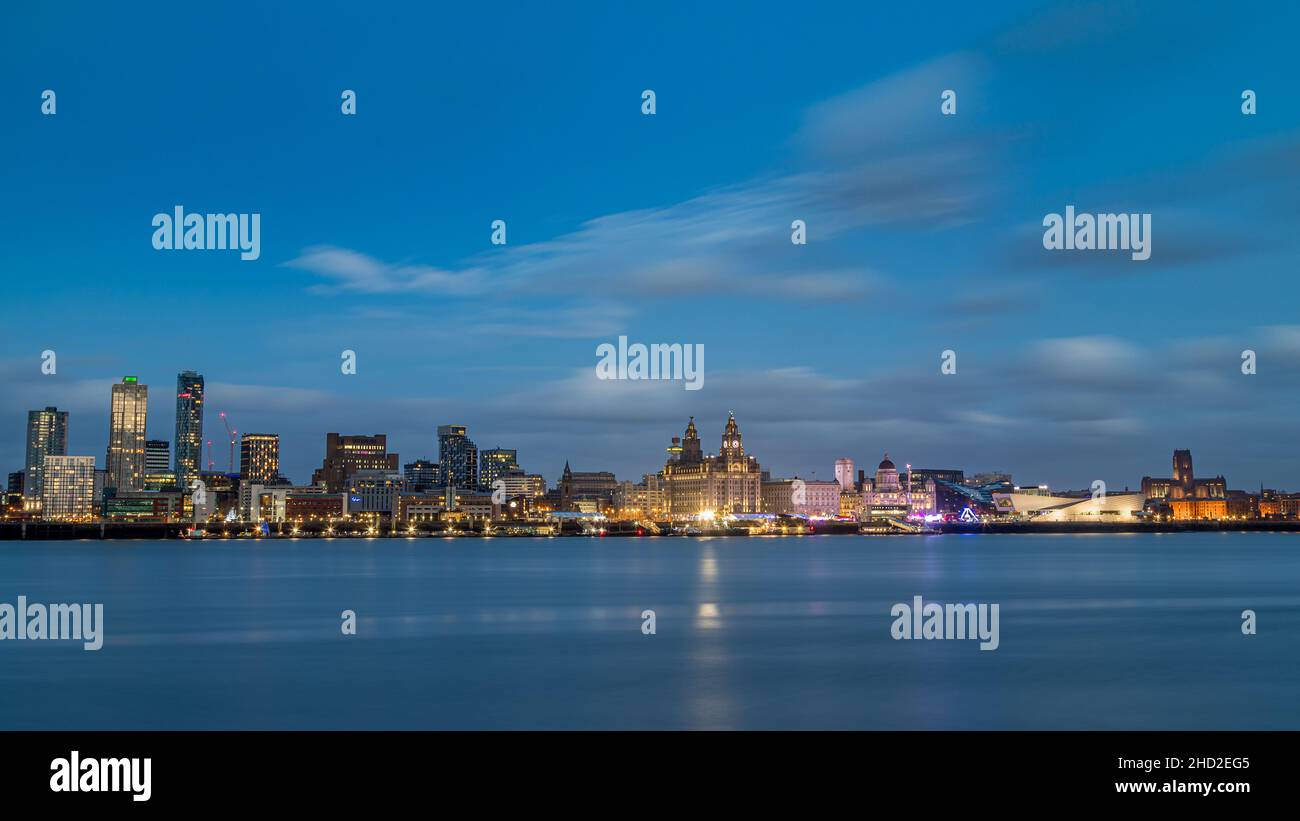 Ein Briefkastenschnitt der Skyline von Liverpool über einem spiegelnden Fluss Mersey am Neujahrstag 2022. Die neueren Gebäude auf der linken Seite des Rahmens begi Stockfoto