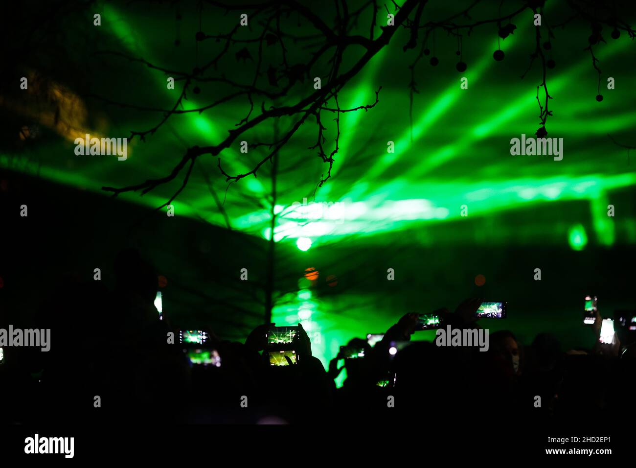 Bukarest, Rumänien - 1. Januar 2022: Während der Neujahrsfeiern im Alexandru Ioan Cuza Park i sehen und Filmen Menschen eine Lasershow über dem See Stockfoto