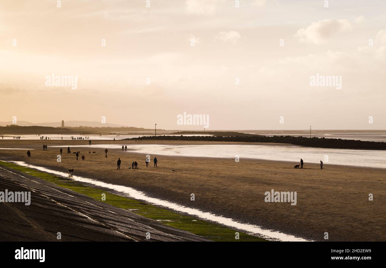 Leaseowe Beach bei Ebbe eingefangen angesichts der späten Nachmittagssonne am 1. Januar 2022, Silhouetten Leaseowe Leuchtturm in der Ferne. Stockfoto