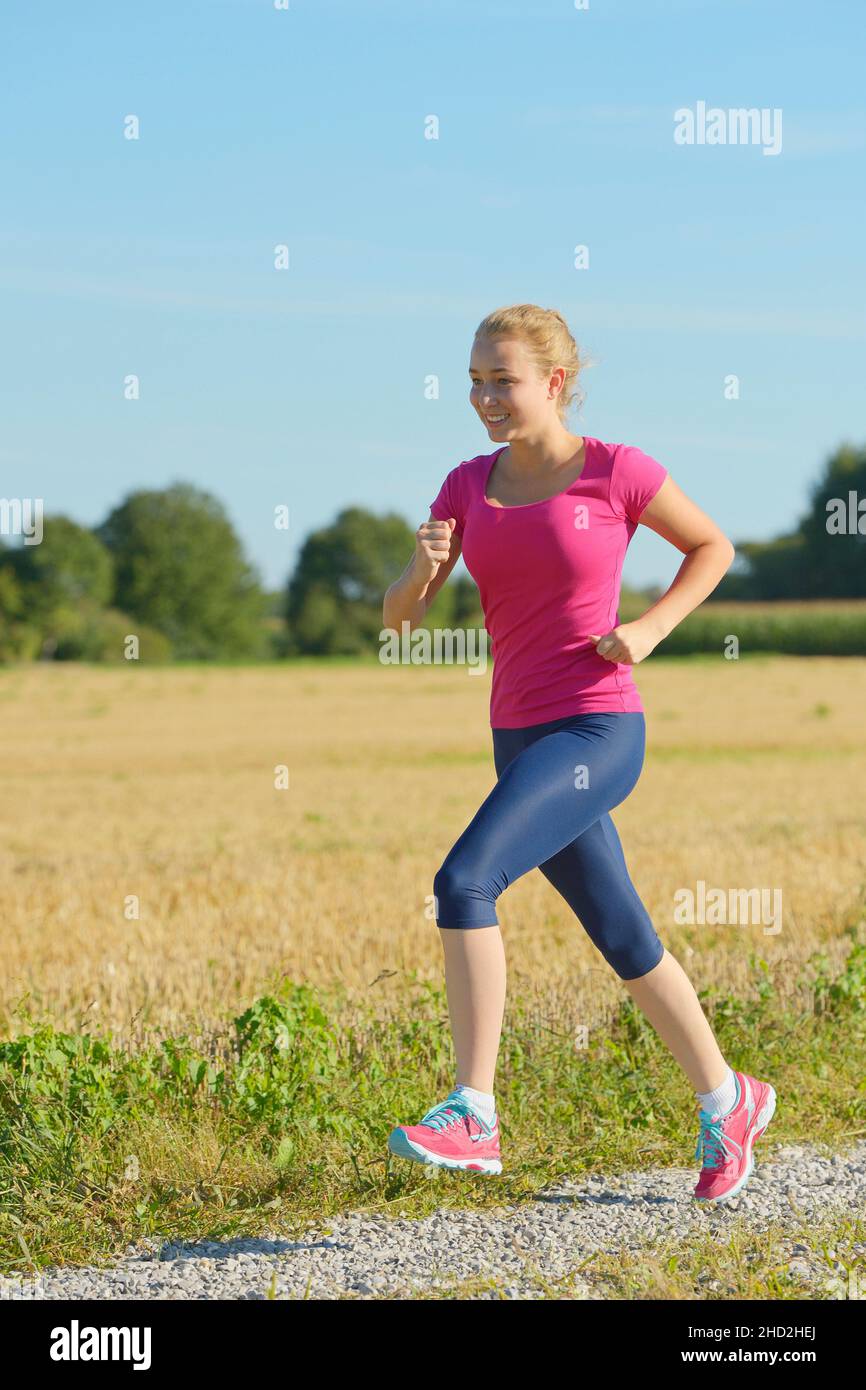 16-jähriges Mädchen läuft im Sommer Stockfoto