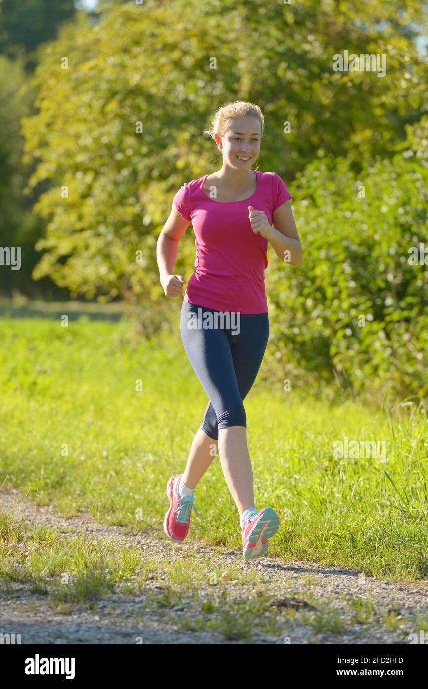 16-jähriges Mädchen läuft im Sommer Stockfoto