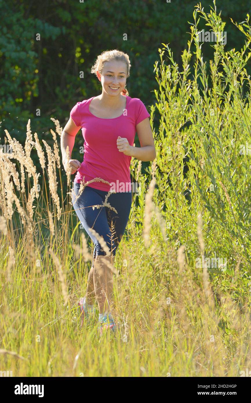 16-jähriges Mädchen läuft im Sommer Stockfoto