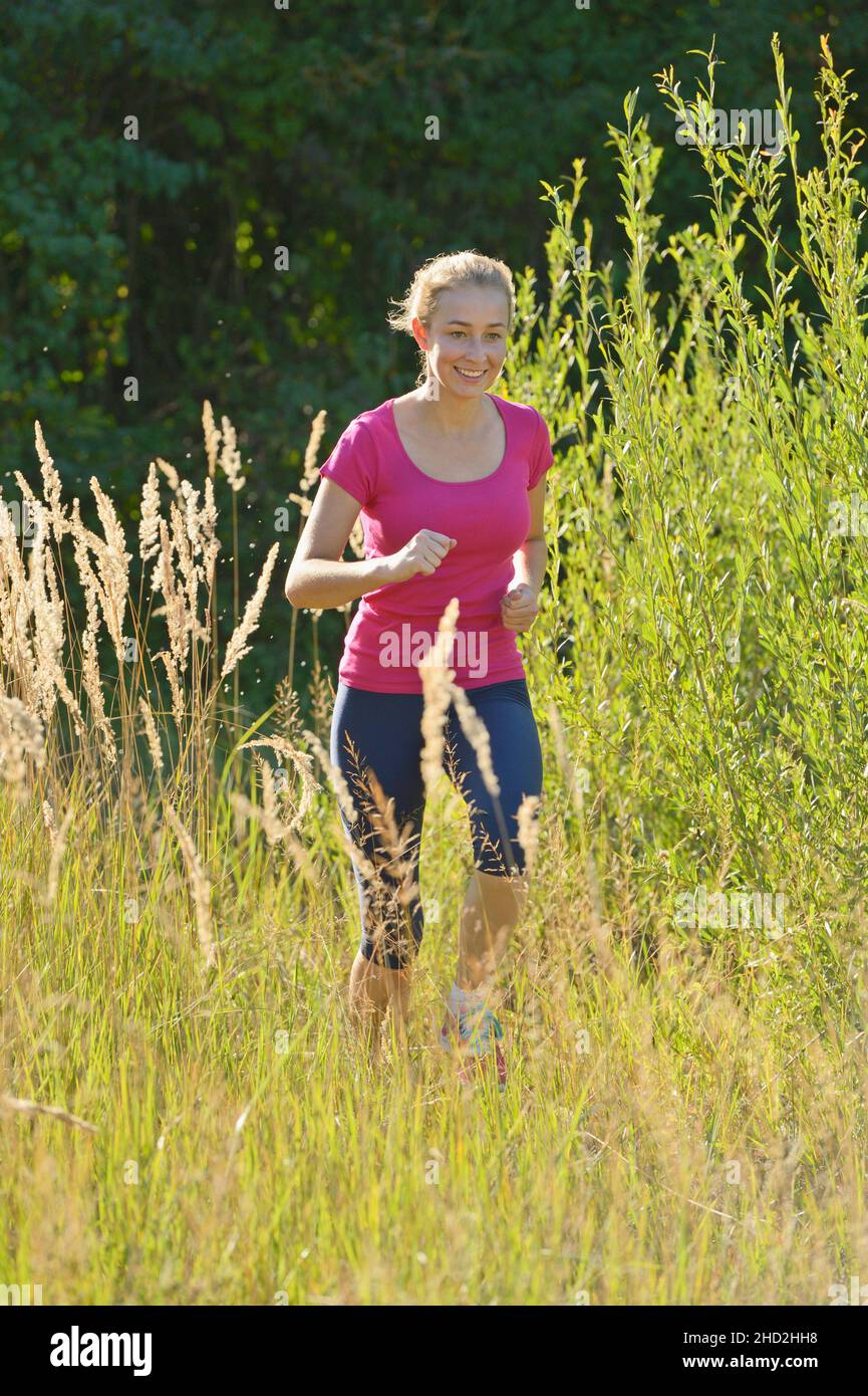 16-jähriges Mädchen läuft im Sommer Stockfoto