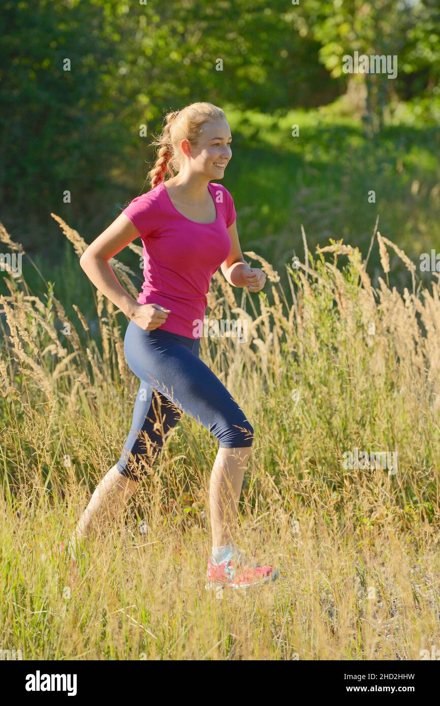 16-jähriges Mädchen läuft im Sommer Stockfoto