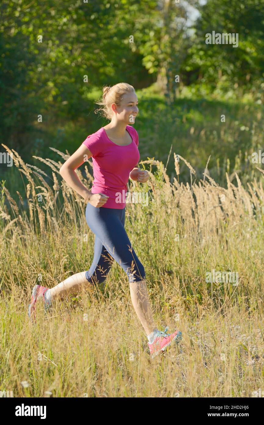 16-jähriges Mädchen läuft im Sommer Stockfoto