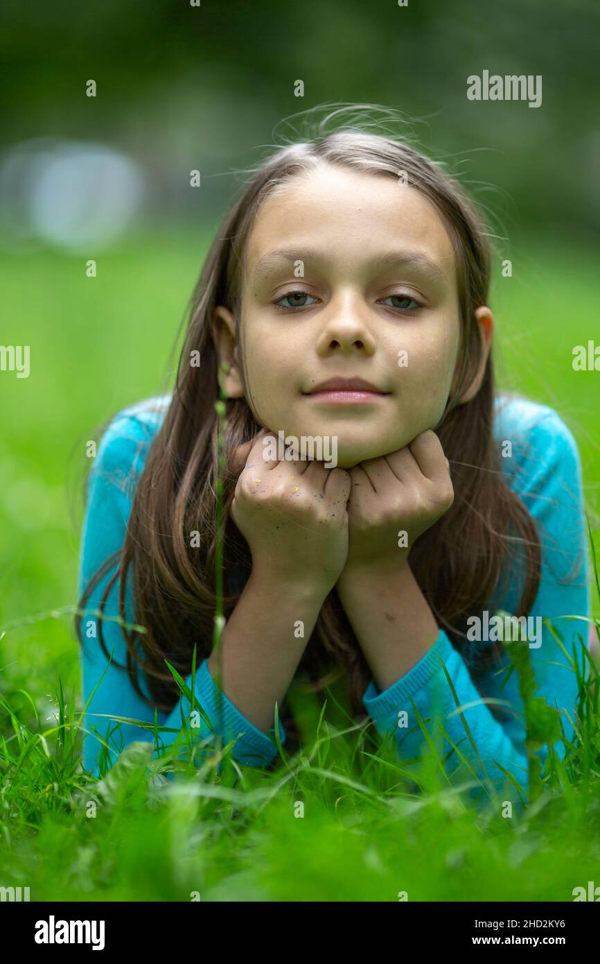 Porträt eines Teenagers, das auf grünem Gras liegt. Stockfoto